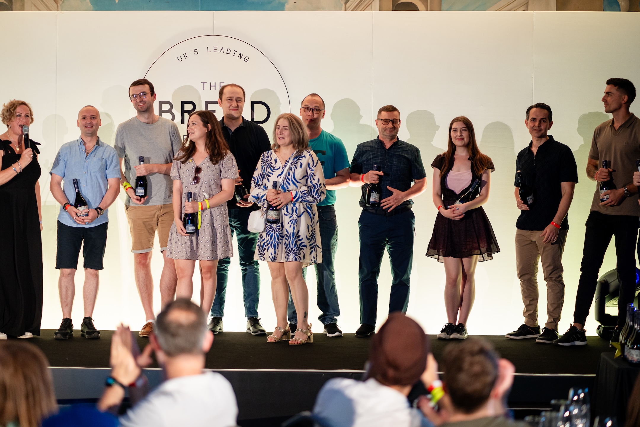 People holding bottles on stage.
